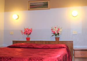 a bedroom with two vases of flowers on a bed at Hotel Eurorooms in Rome