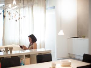 una mujer sentada en una mesa mirando un celular en Soardi Accommodation for business & funny, en Rímini 15 fotos más