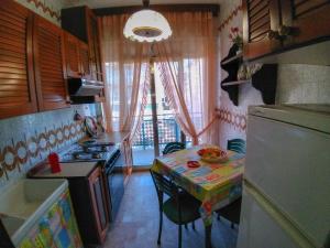 eine kleine Küche mit einem Tisch und eine kleine Küche mit einem Waschbecken in der Unterkunft Appartamenti Padoan in Sottomarina