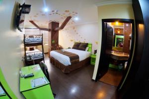 a bedroom with a bed with a cross on the wall at Hotel Mary Carmen in Ambato