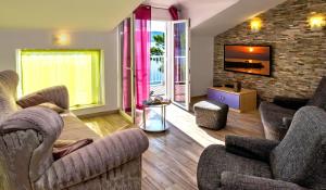 een woonkamer met twee stoelen en een tv bij Apartments Velo Lago in Lastovo