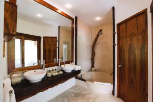 a bathroom with two sinks and a large mirror at The Beach Tulum in Tulum