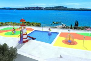 een speeltuin met een zwembad en een vuurtoren bij Hotel Medena Budget in Trogir