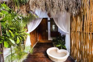 a bathroom with a heart shaped toilet in a room with plants at The Beach Tulum Hotel in Tulum