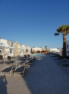 a row of chairs and umbrellas next to a pool at Los Gracioseros in Puerto del Carmen