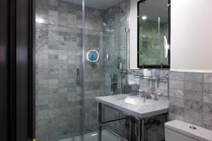ein Bad mit einer Dusche, einem Waschbecken und einem Spiegel in der Unterkunft The Academy - Small Luxury Hotels of the World in London