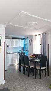 Apartamentos Osma في سانتا مارتا: مطبخ وغرفة طعام مع طاولة وكراسي