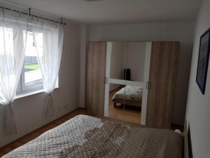 um quarto com um espelho, uma cama e uma janela em Großes Ferienhaus in Hannover Messe Nähe em Sarstedt