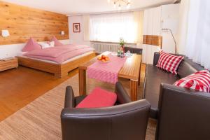 a living room with a bed and a table and chairs at Ferienhaus Kessler in Riezlern +10 photos