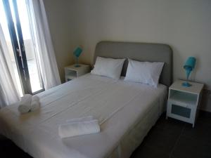 1 dormitorio con 1 cama blanca grande y toallas. en Albatross House, en Livadáki
