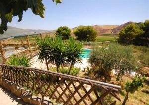a wooden bench in a garden with a swimming pool at Terra Nostra in Cattolica Eraclea