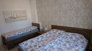 a bedroom with two beds and a picture on the wall at Apartments Budin Adri & Robi Rijeka City Center in Rijeka