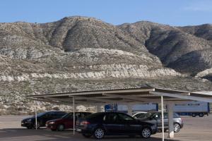 a parking lot with cars parked in front of a mountain at Hotel Pepa in Villafranca de Ebro