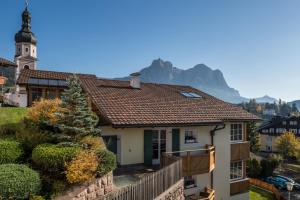 a house with a church and a mountain in the background at Residence Diamant in Castelrotto