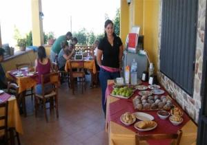 a woman standing next to a table with food on it at Terra Nostra in Cattolica Eraclea