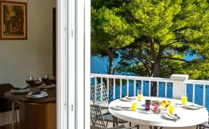 a table and chairs on a balcony with a view of the ocean at Apartments Velo Lago in Lastovo