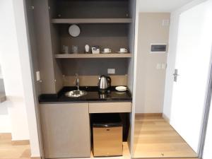 a small kitchen with a sink and shelves at Avellaneda Aparts & Suites in Buenos Aires