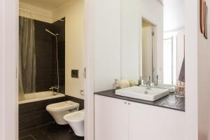 een witte badkamer met een wastafel en een toilet bij Chão do Loureiro Apartments Baixa-Castle in Lissabon