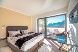 a bedroom with a bed and a balcony with a view at Chalet Agave in Caldaro
