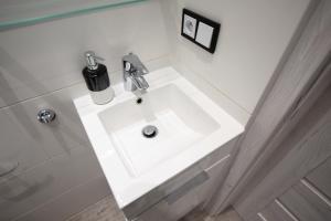 W pokoju znajduje się łazienka z białą umywalką. w obiekcie Apartament Manufaktura w Łodzi