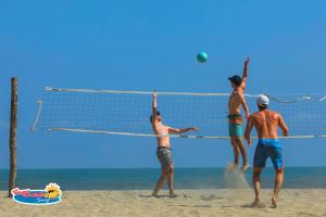 a group of men playing volleyball on the beach at Casa Grande Surf in Guachaca