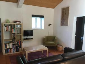 uma sala de estar com um sofá, uma mesa e uma televisão em Quinta Boavista em Cercal do Alentejo