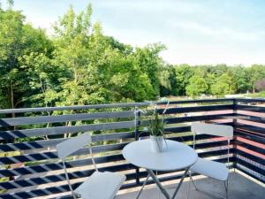 a white table and chairs on a balcony at Przy Plaży in Karwia