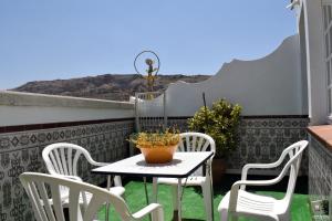 een tafel en stoelen op een balkon met een tafel bij Casa Rural El Puente in Cuevas del Becerro