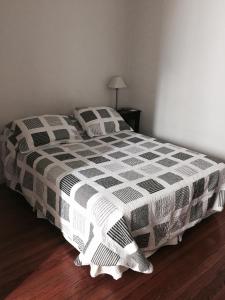 1 dormitorio con 1 cama con edredón blanco y negro en Monoambiente en el centro de Recoleta en Buenos Aires