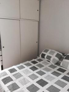 1 dormitorio con 1 cama con sábanas blancas y negras a cuadros en Monoambiente en el centro de Recoleta en Buenos Aires