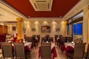 a restaurant with tables and chairs in a room at Corfu Secret in Ipsos