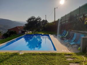 a swimming pool with chairs next to a wall at Casas do Casinhoto - Casa Vista Aregos in Baião