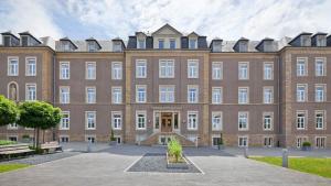 un gran edificio de ladrillo con patio en Hotel-Résidence Am Klouschter en Mondorf-les-Bains