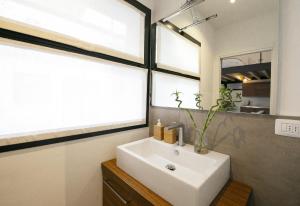 La salle de bains est pourvue d'un lavabo blanc et d'un miroir. dans l'établissement Design Central Apartment, à Bergame