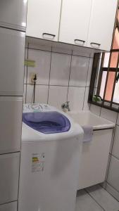 a bathroom with a toilet with a purple lid at Apartamento Meia Praia - 140 metros do mar in Itapema