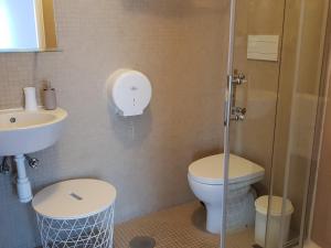La salle de bains est pourvue de toilettes, d'un lavabo et d'une douche. dans l'établissement 100 Contos, à Porto