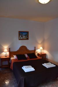 une chambre avec un grand lit avec deux serviettes dessus dans l'établissement La Fonda Aeropuerto, à Ingenio