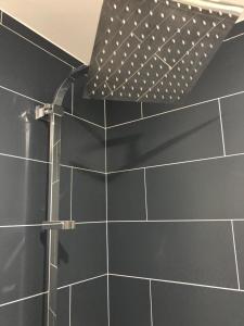 un bagno con doccia e piastrelle nere di CANNES SERGENT GAZAN a Cannes Altre 6 foto