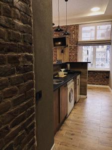 uma cozinha com um balcão e uma parede de tijolos em Apart18 em Lviv