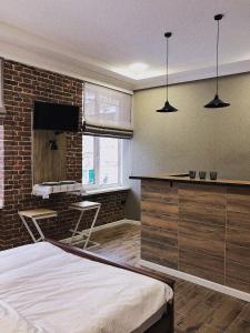 ein Schlafzimmer mit einem Bett und einer Ziegelwand in der Unterkunft Apart18 in Lwiw