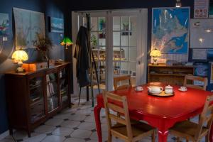 uma sala de jantar com uma mesa vermelha e cadeiras em Auberge jeunesse Rose des Vents em Sainte-Rose-du-Nord