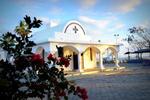 eine kleine weiße Kirche mit einem Kreuz darüber in der Unterkunft Ocean Dreams Suites in Ayia Napa