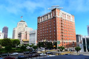 a tall red brick building in a city at Huntington Hotel in San Francisco