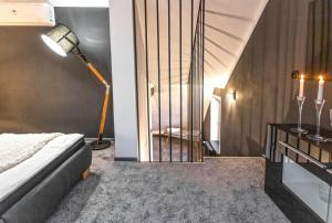 a bedroom with a bed and a lamp and a staircase at Apartment Charlie in Prague
