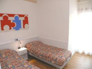 Habitación pequeña con 2 camas y ventana en Bibione Mastervillage, en Bibione