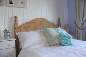 a bed with a wooden headboard and two pillows on it at Cairnview Bed and Breakfast in Larne
