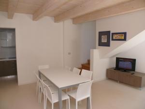 uma sala de jantar com uma mesa branca e cadeiras brancas em Bibione Mastervillage em Bibione