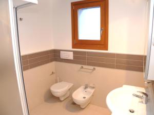 uma casa de banho com um WC e um lavatório em Bibione Mastervillage em Bibione