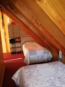 1 dormitorio con 2 camas en un ático en Cabaña Centrica, en Coyhaique