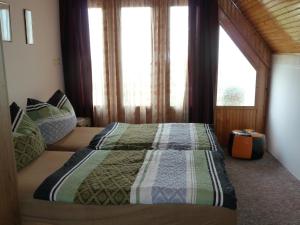 ein Schlafzimmer mit einem Bett in einem Zimmer mit Fenstern in der Unterkunft House Sophie in Vonyarcvashegy